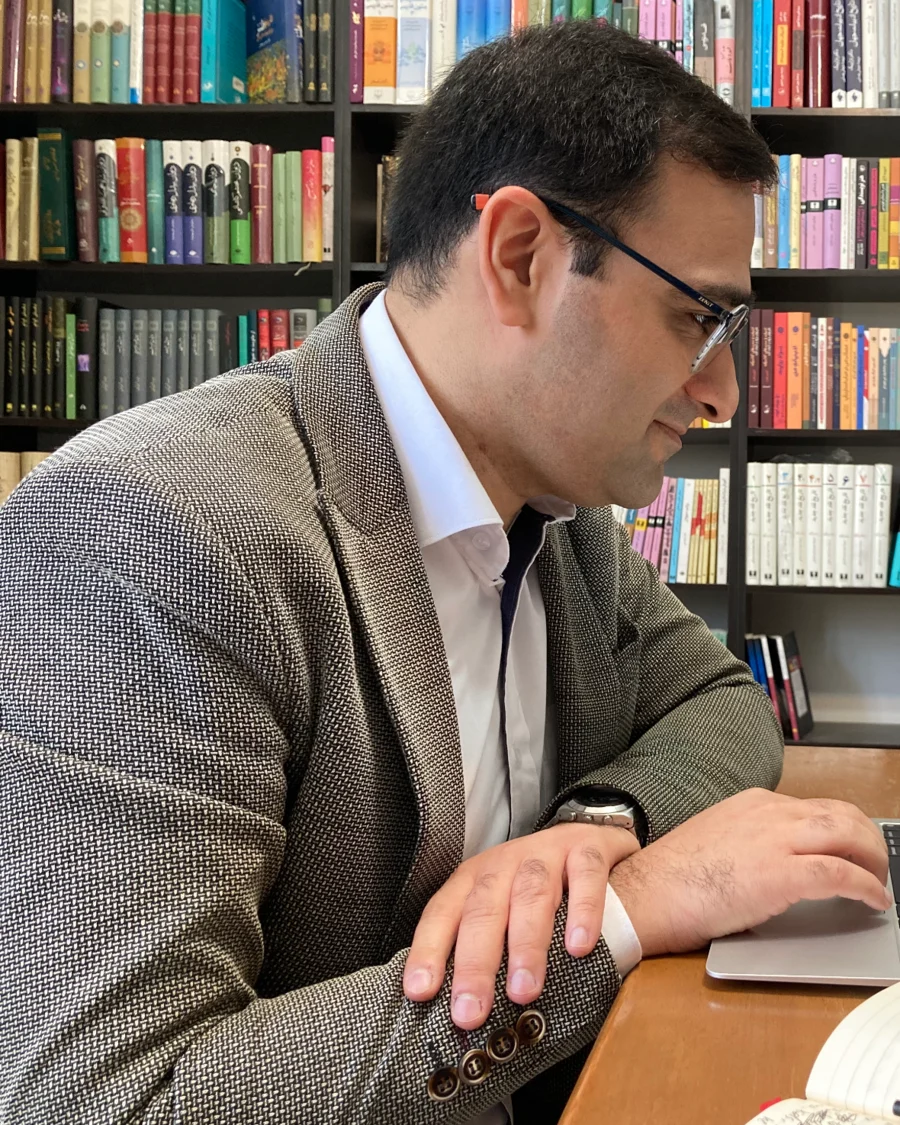 Pouyan Assar working at a laptop in a library